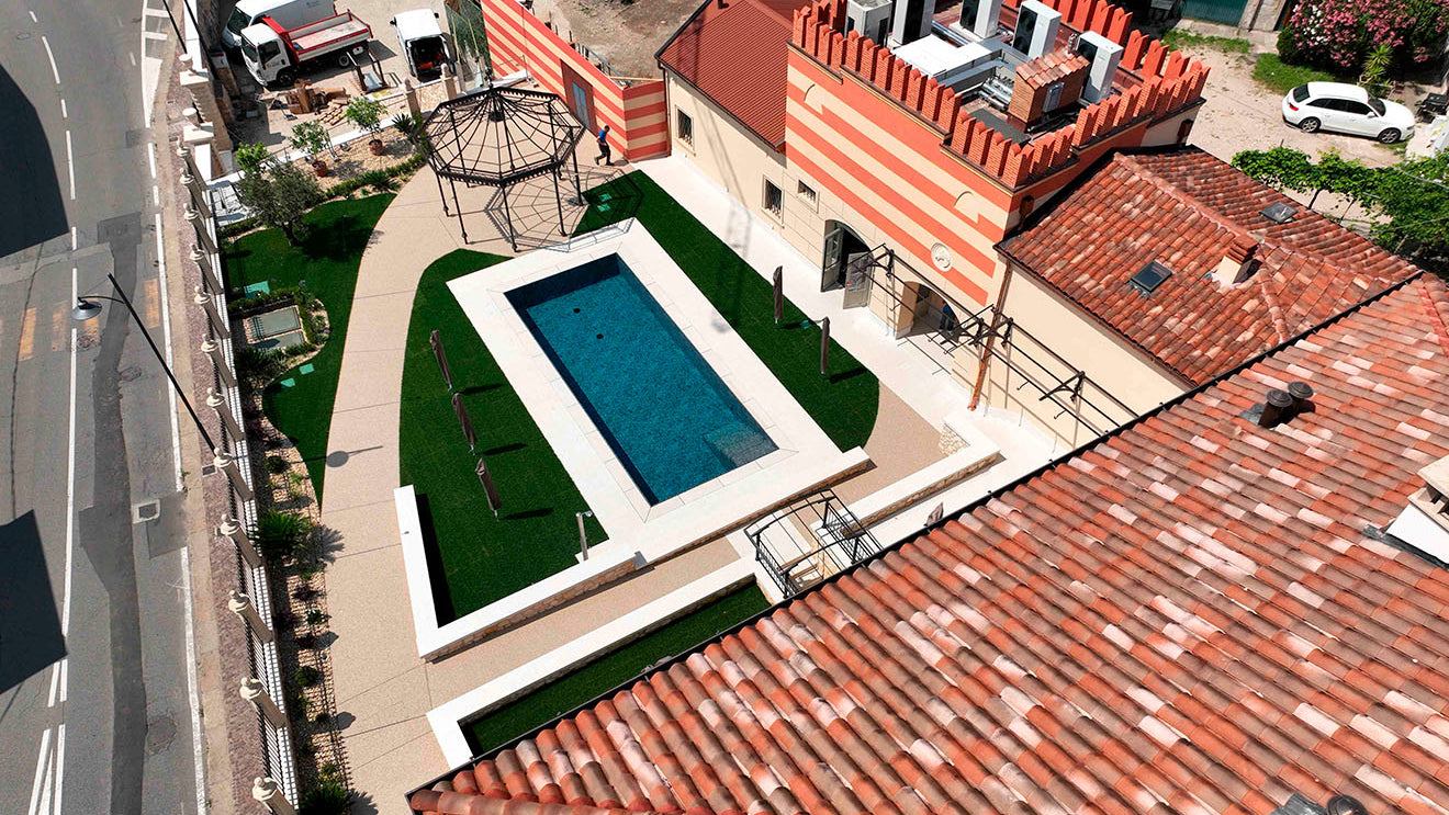 Piscina a Sfioro by Zavatti Piscine rettangolare senza vasca di compenso con gradini interni e rivestimento nero marmorizzato a Caldiero (VR)