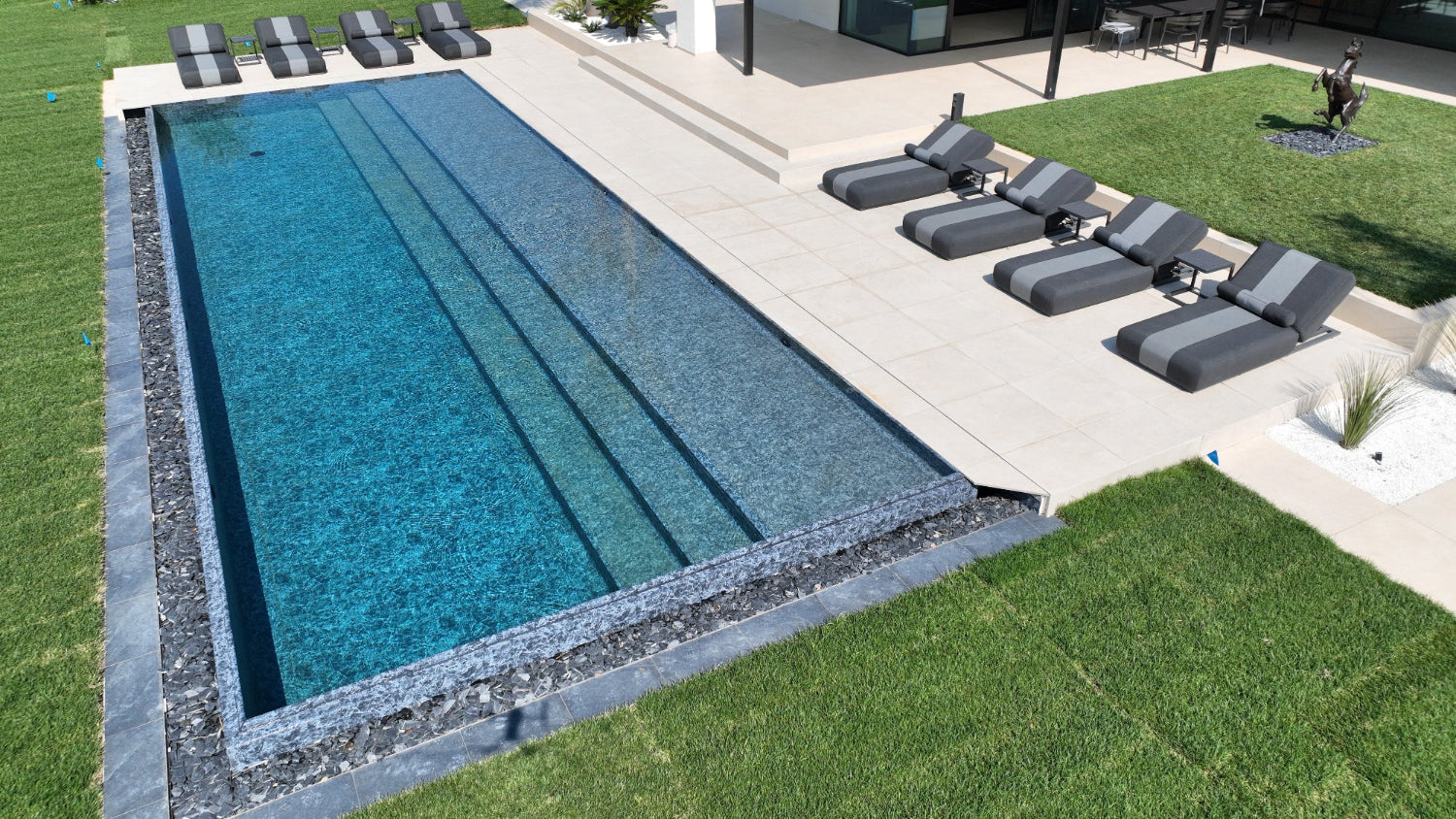 Piscina a sfioro Lazise con effetto cascata nero marmorizzato spiaggia a tutta lunghezza