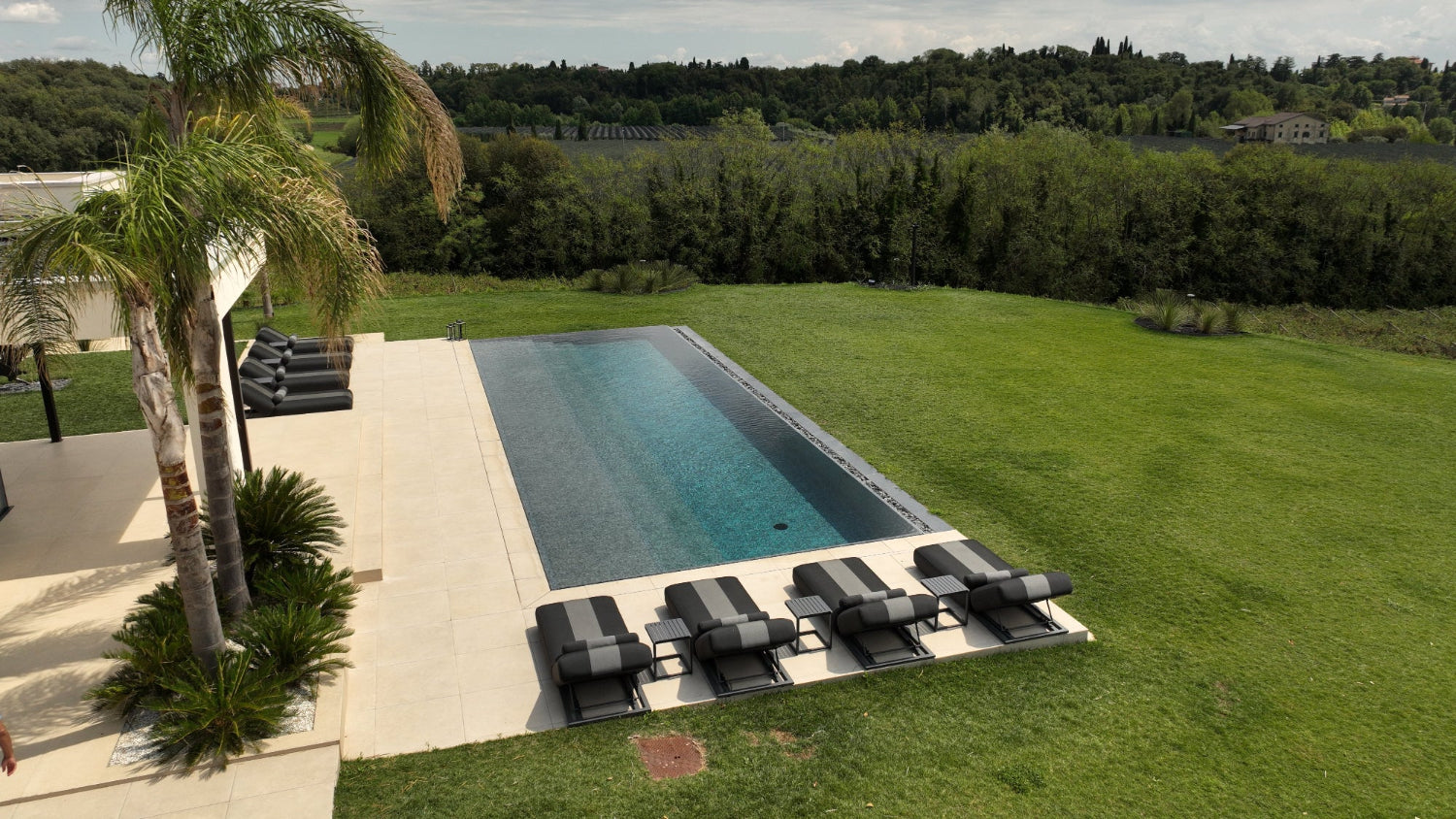 Piscina a sfioro Lazise con effetto cascata nero marmorizzato spiaggia a tutta lunghezza Lago di Garda