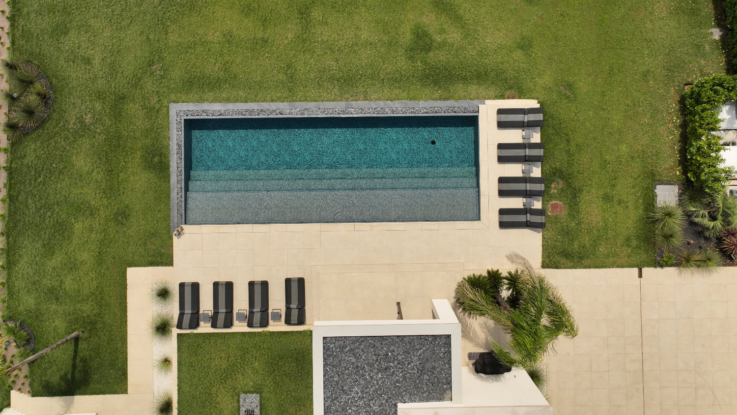 Piscina a sfioro Lazise con effetto cascata nero marmorizzato spiaggia a tutta lunghezza Lago di Garda design lusso