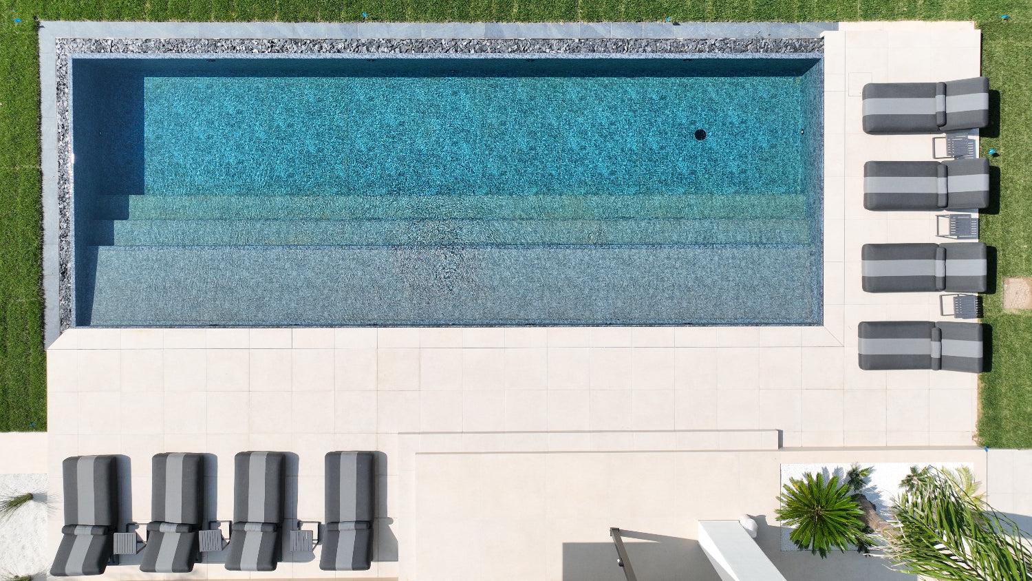 Piscina a sfioro Lazise con effetto cascata nero marmorizzato spiaggia a tutta lunghezza Lago di Garda design moderno