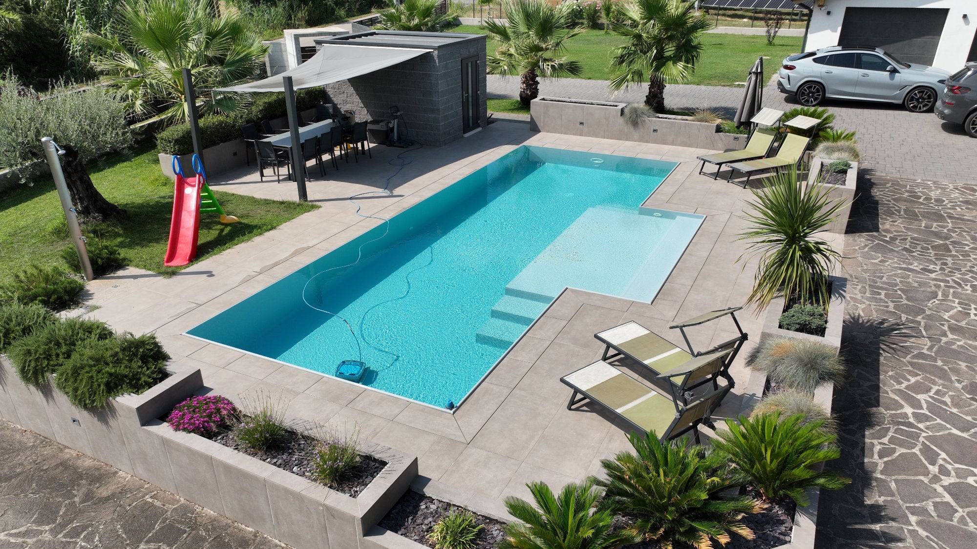 Piscina a sfioro a Gazzo Veronese, rivestimento chiaro, spiaggia semi esterna centrale