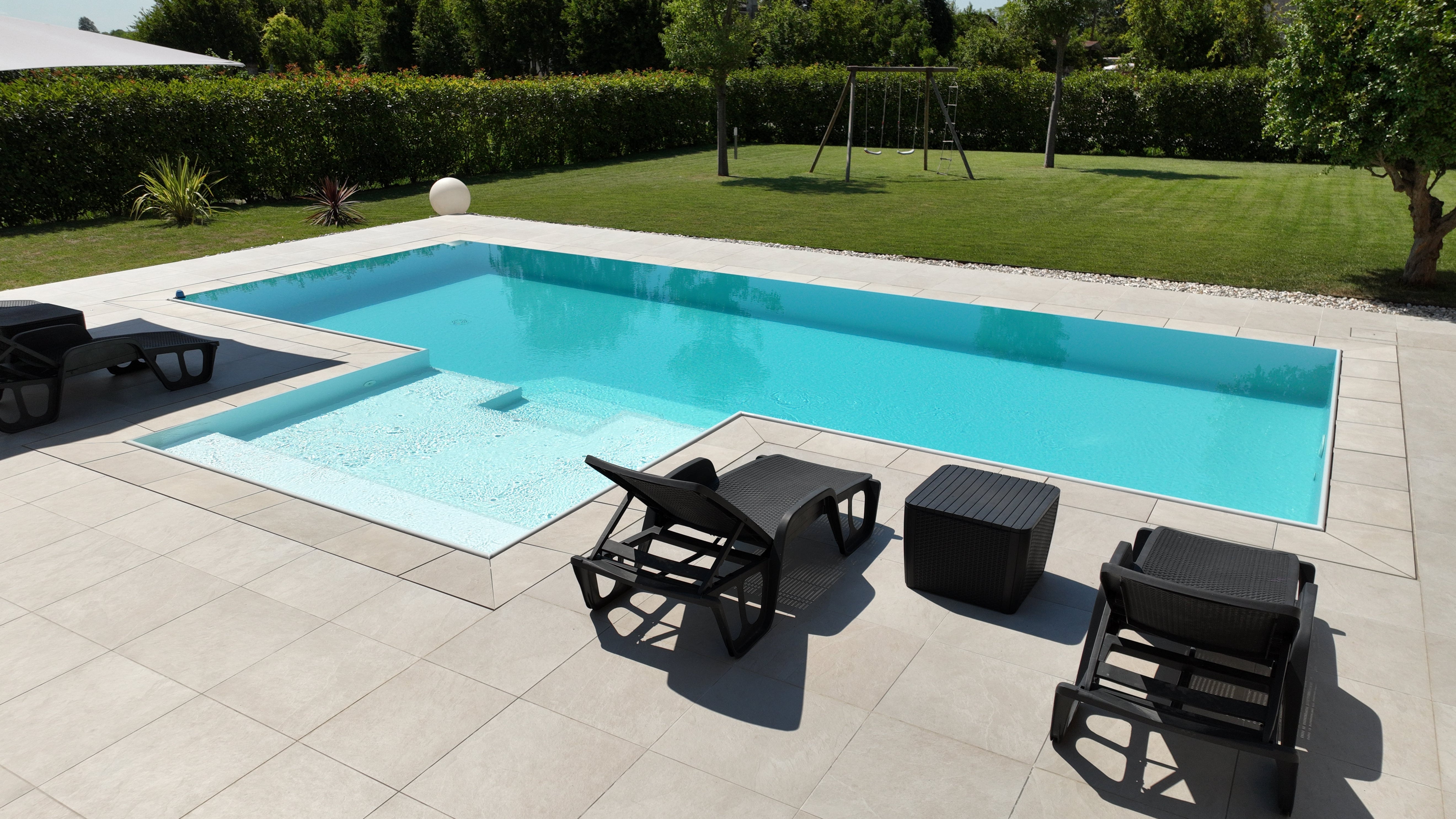 Piscina a sfioro con rivestimento chiaro, realizzata a San Biagio di Callalta, Treviso