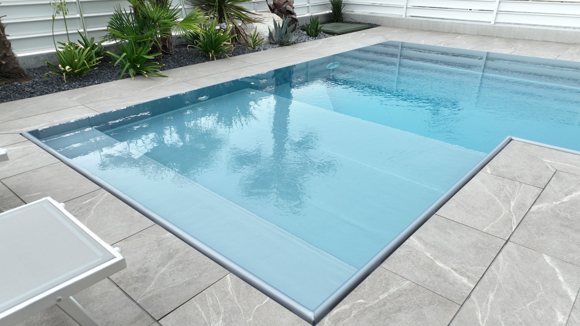 Piscina  a sfioro con rivestimento silver in casa moderna