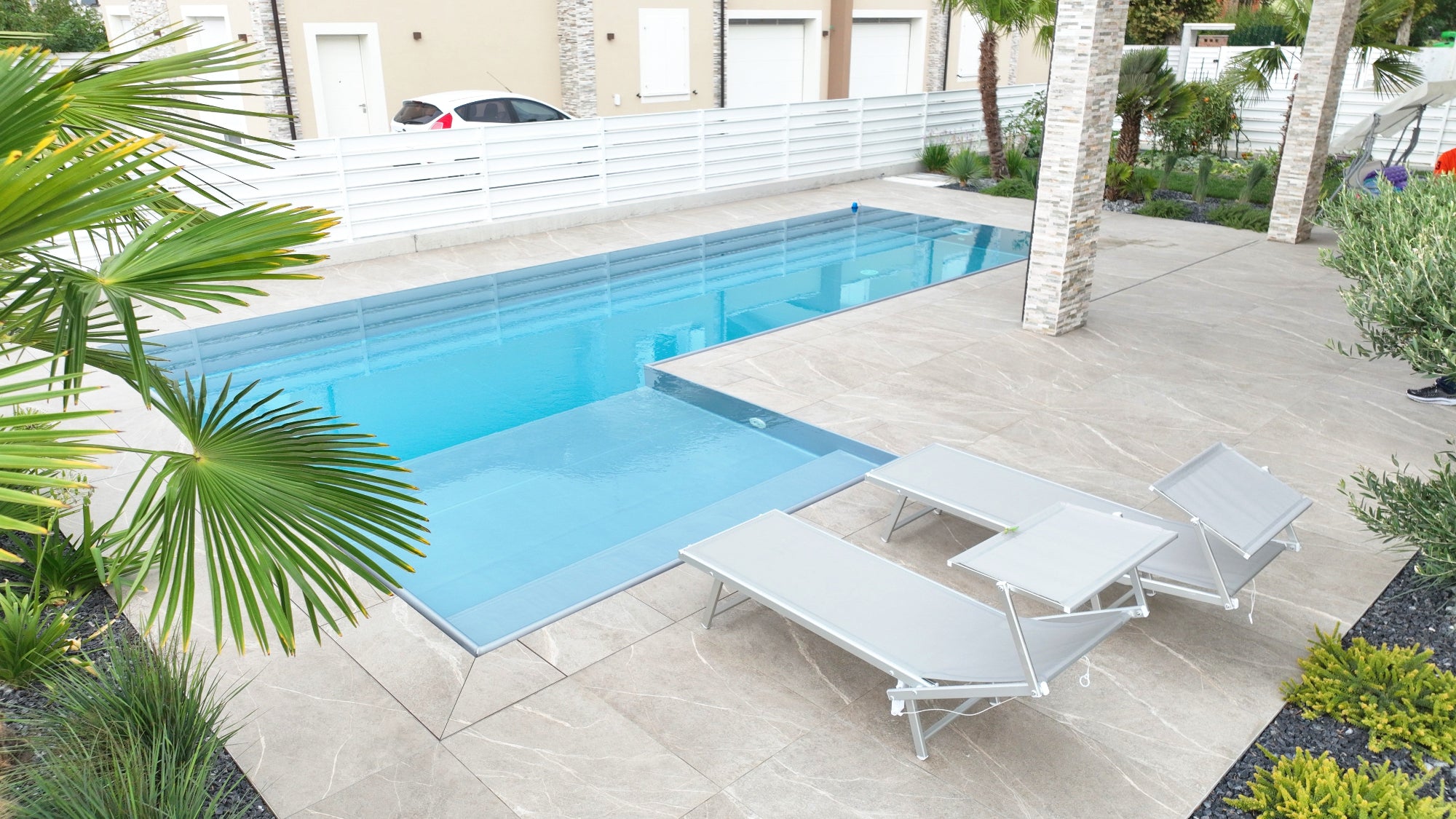 Piscina a sfioro realizzata a San Secondo Parmense con spiaggia esterna laterale