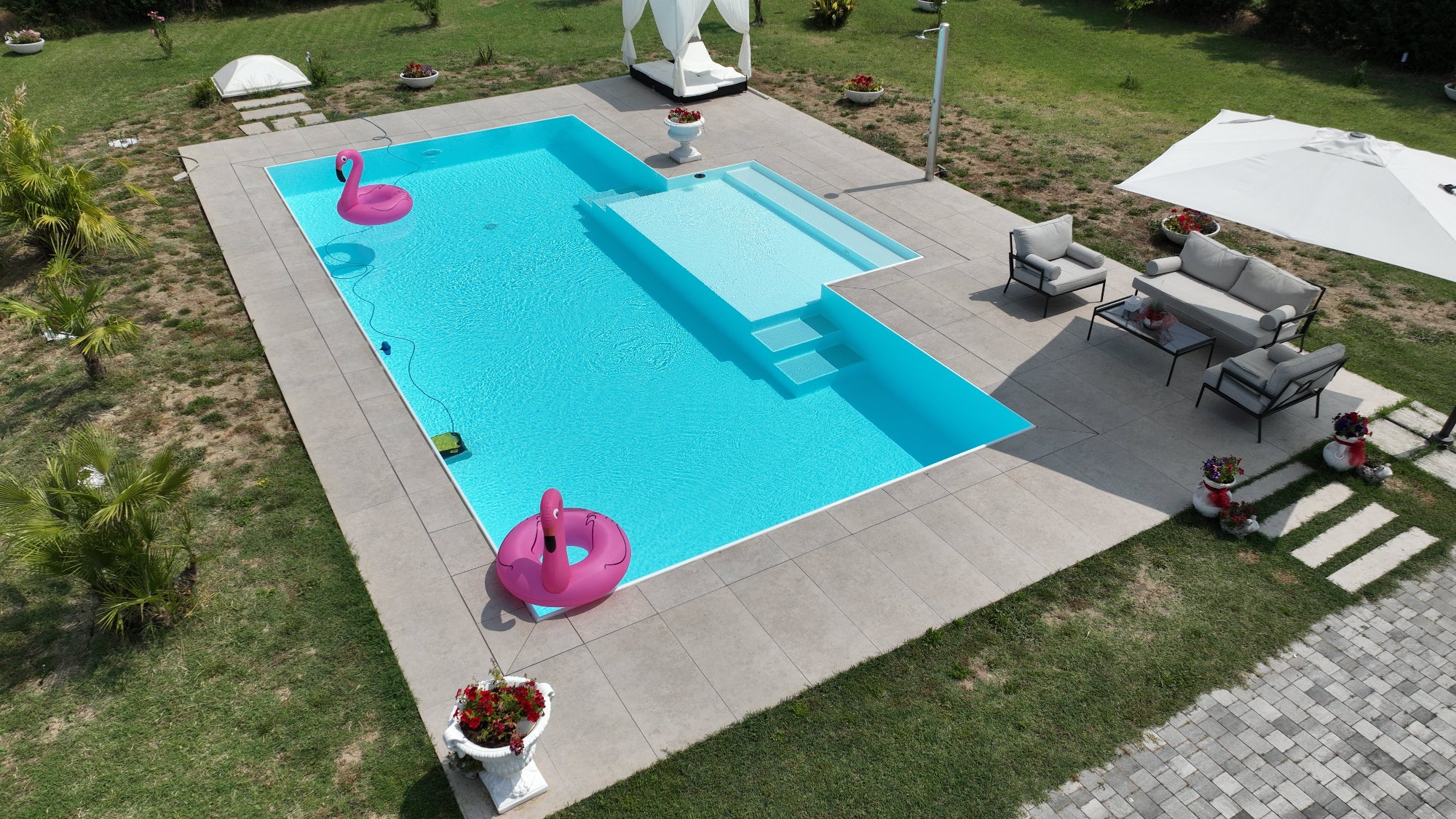 Piscina a sfioro rettangolare bianca con spiaggia semiesterna centrale, autopulente e di facile gestione, senza vasca di compenso