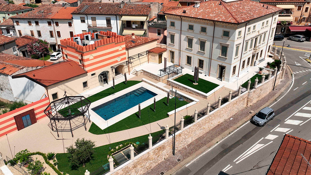 Piscina rettangolare a Sfioro senza vasca di compenso con gradini interni rivestimento nero marmorizzato a Scandiano (VR)