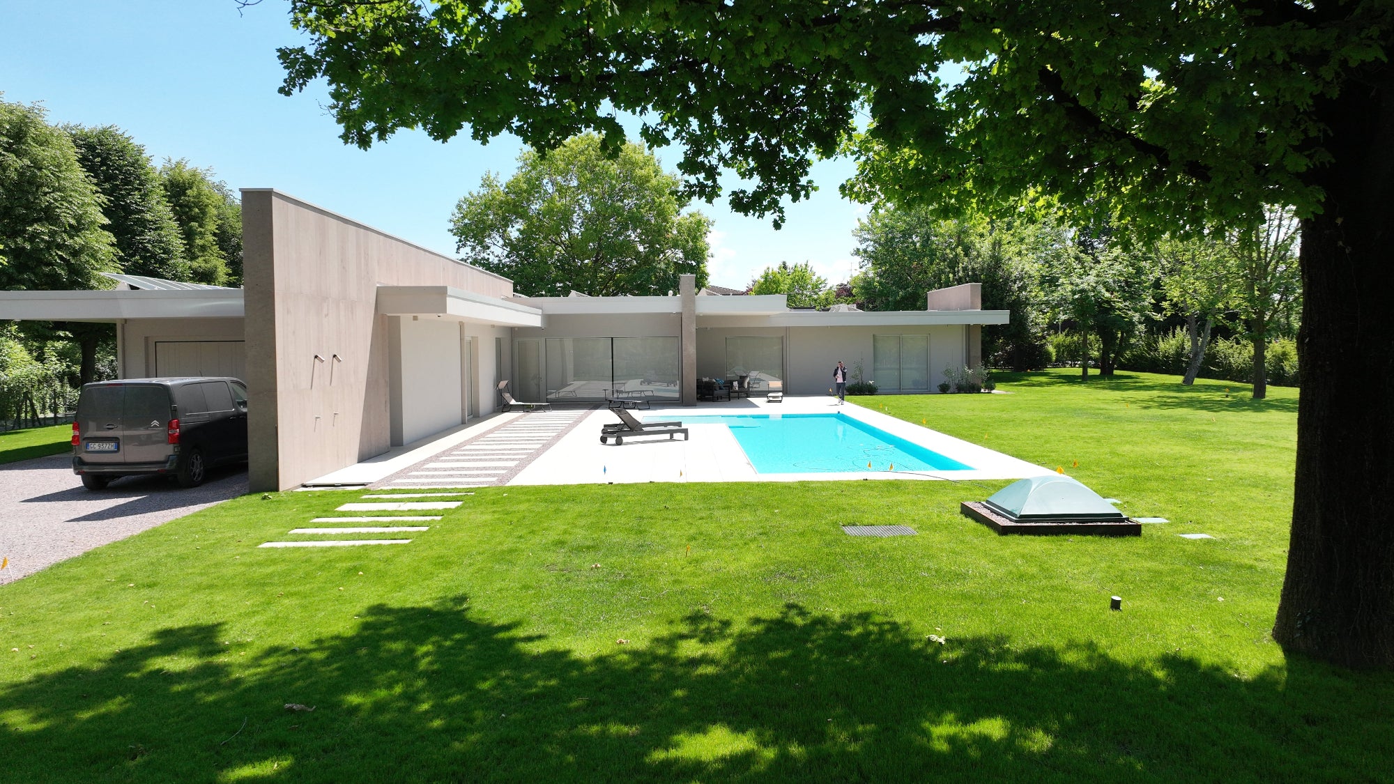 Piscina sfioro a Spilamberto dal design moderno in stile con la casa. Spiaggia esterna ad elle rivestimento bianco