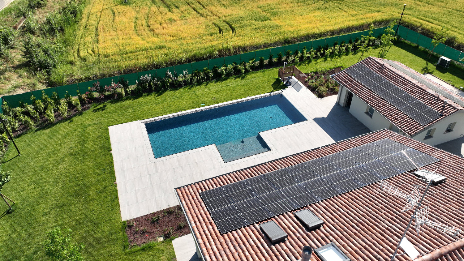 Piscina sfioro senza vasca di compenso esclusiva Zavatti con spiaggia esterna centrale e di nero marmorizzato a Carpi