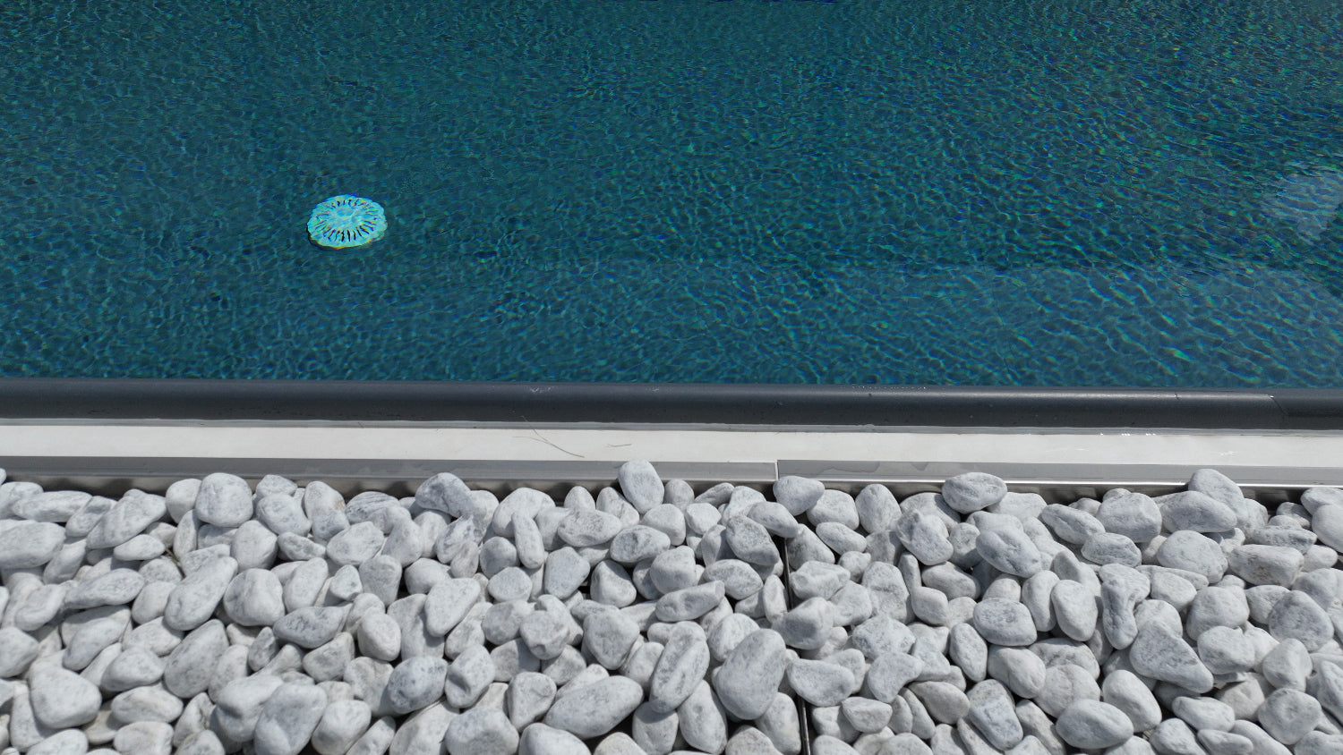 dettaglio vaschette con sassi decorativi, contorno piscina a sfioro moderna