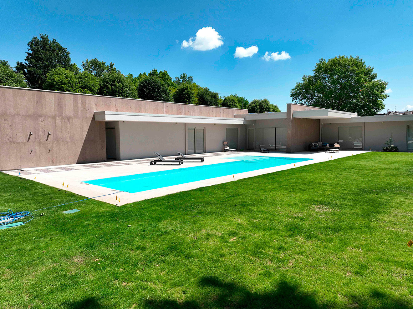 nuova realizzazione casa moderna design giardino piscina a sfioro rivestimento chiaro