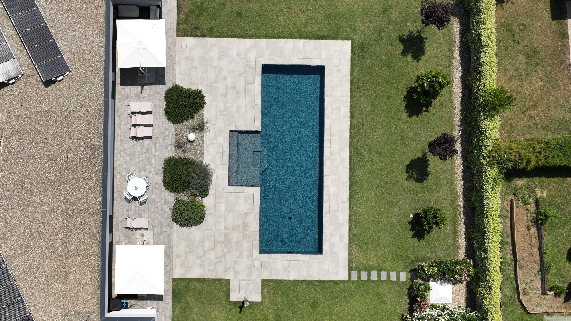 piscina a sfioro MIA senza vasca di compenso nera marmorizzata con spiaggia esterna centrale a Reggio Emilia