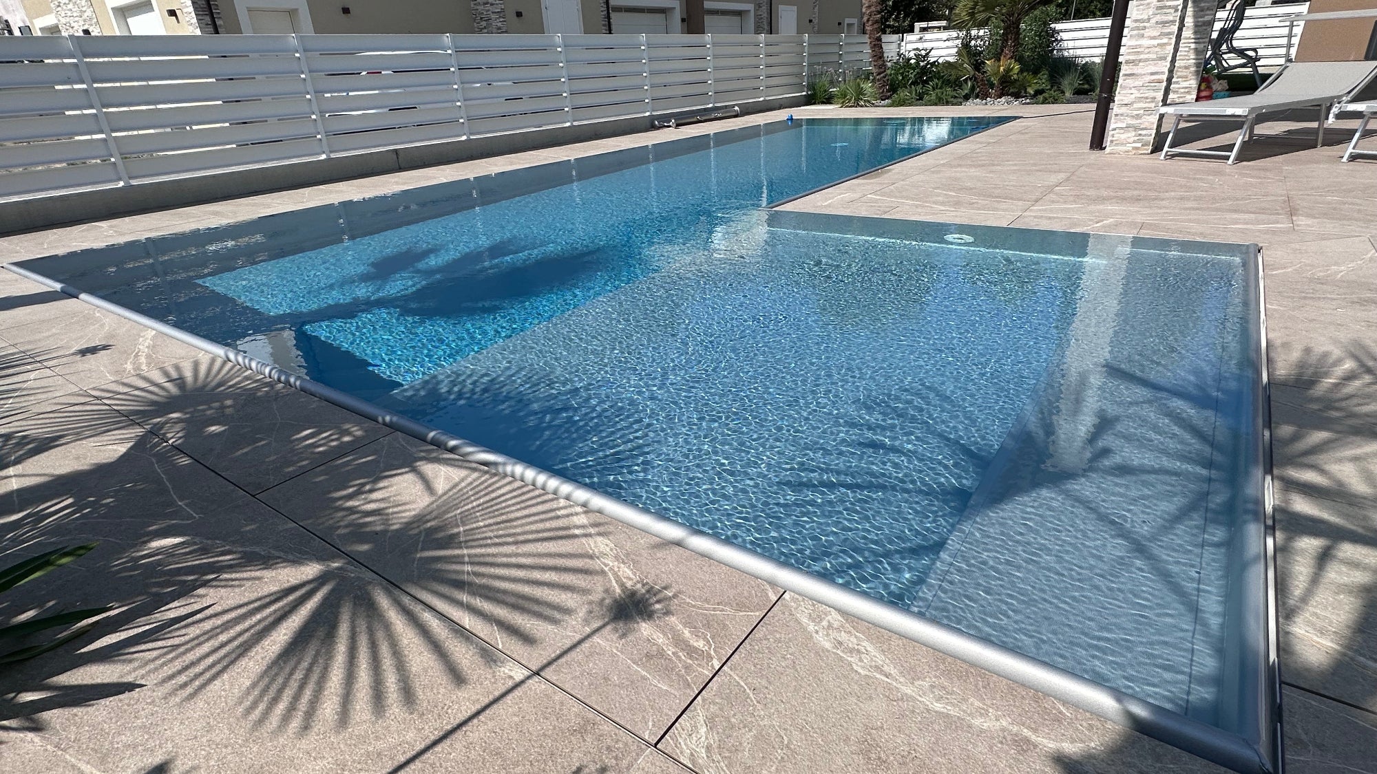 piscina a sfioro a forma di L, grande spiaggia laterale