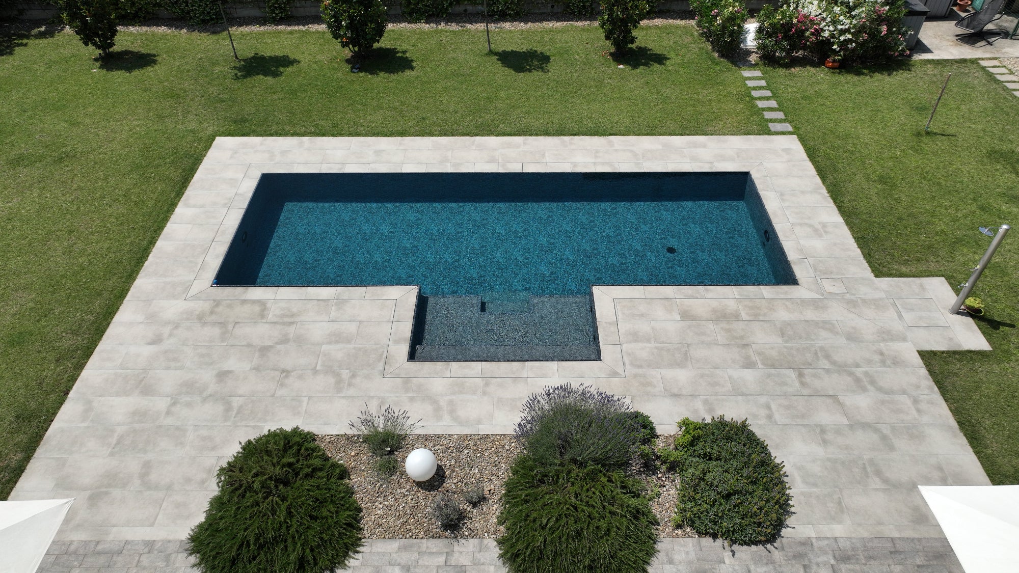 piscina a sfioro nera marmorizzata con spiaggia centrale senza vasca di compenso autopulente, tecnologia MIA by Zavatti