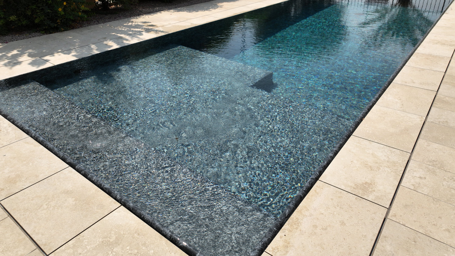 piscina a sfioro senza vasca di compenso rivestita con color marmo nero