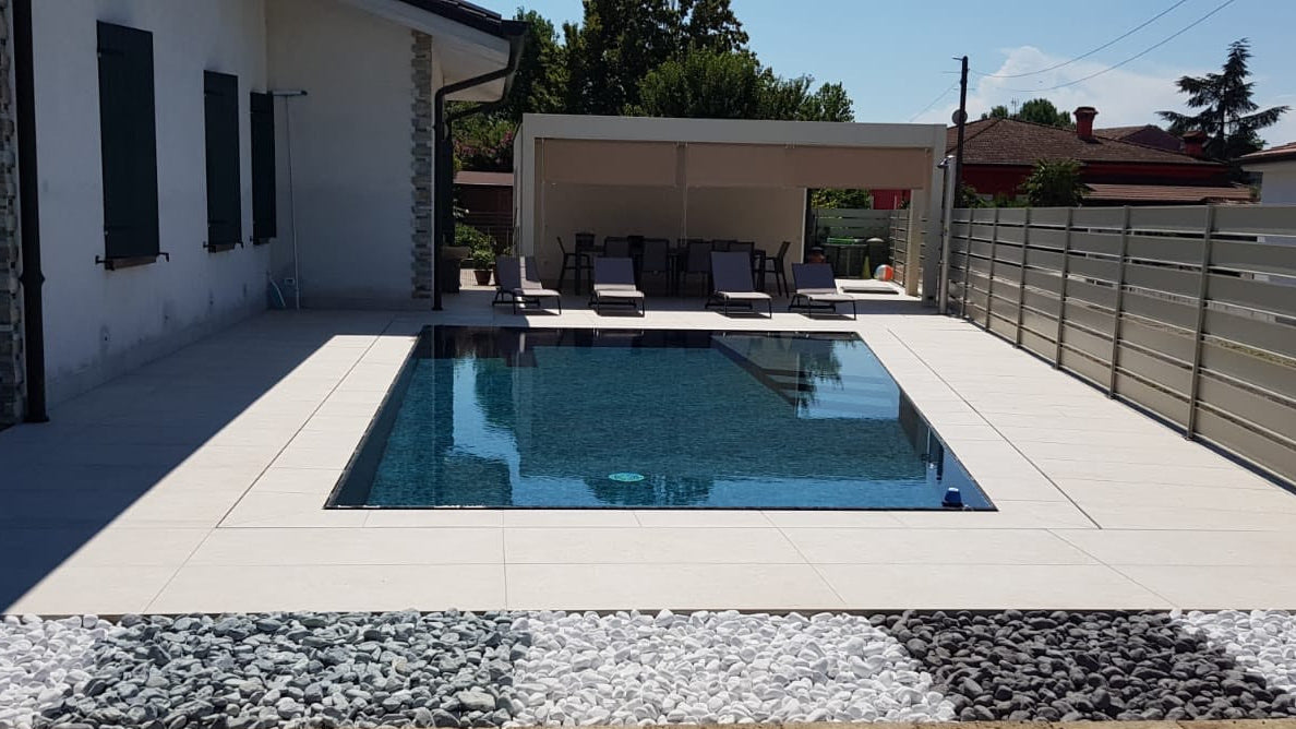 piscina con forma asimmetrica a sfioro con rivestimento scuro