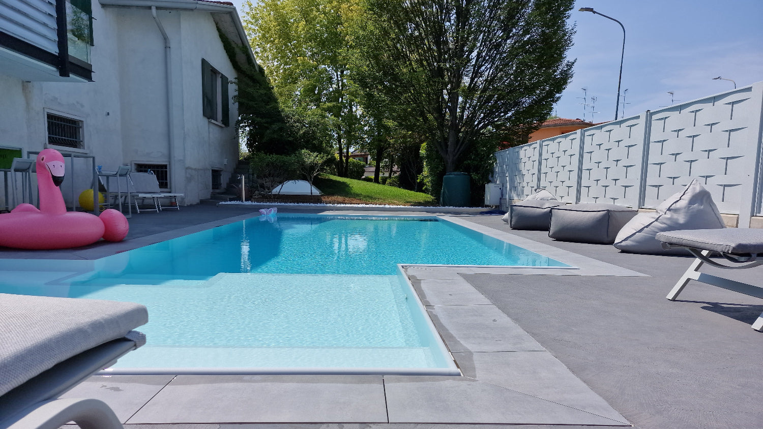 piscina rivestita con colore bianco con spiaggia angolare esterna a Rivalta sul Mincio
