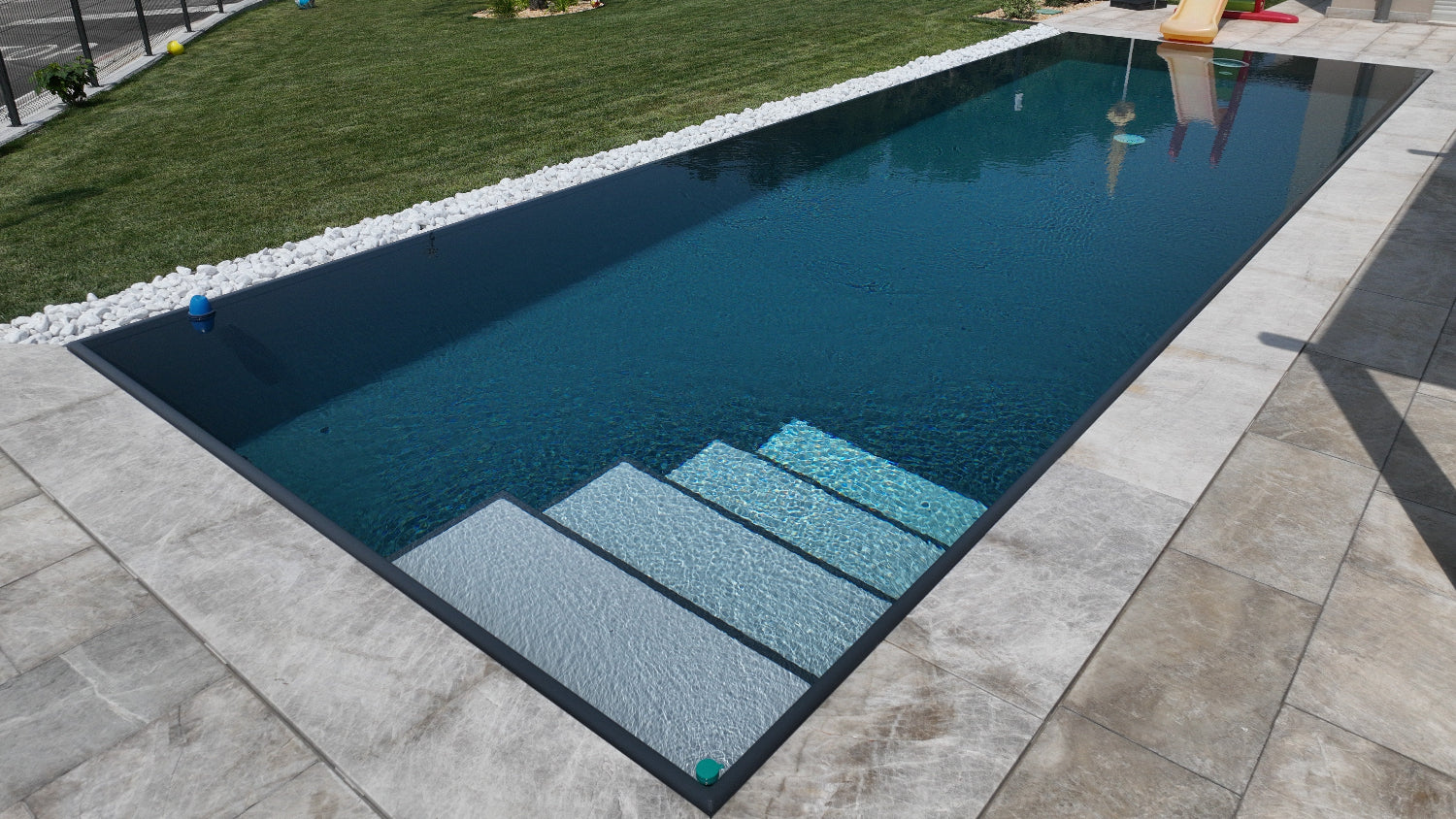 piscina scura rettangolare con scalini di ingresso