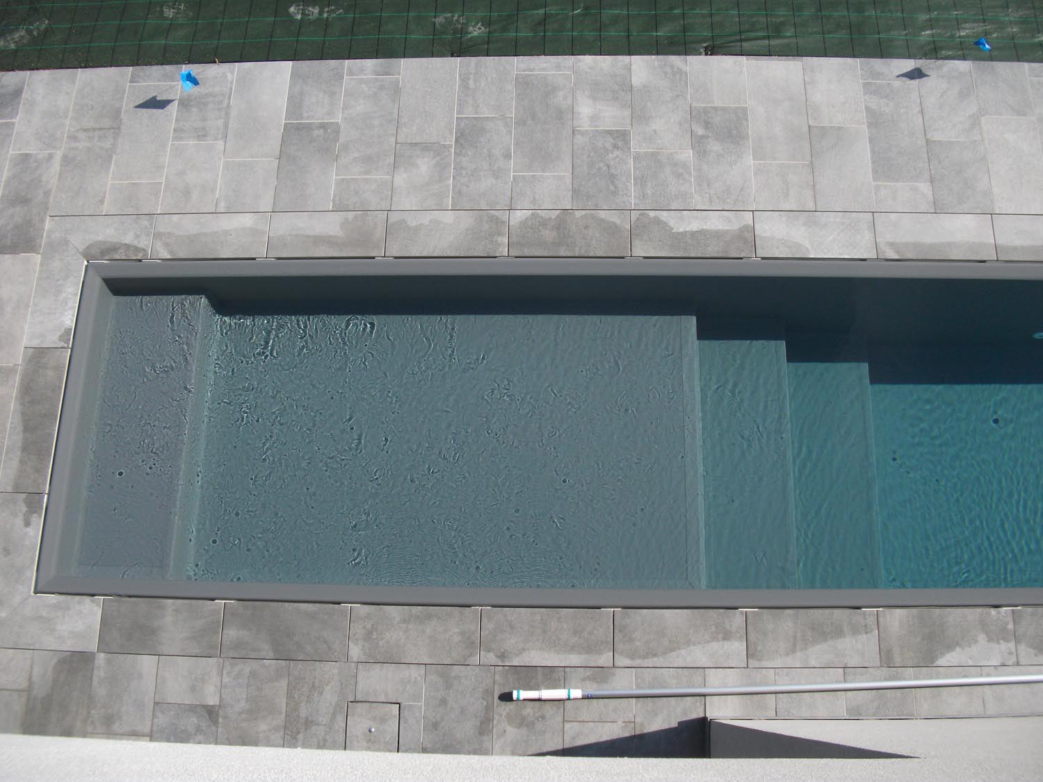 Particolare ingresso laterale di una piscina a sfioro senza vasca di compenso con sfioro a scomparsa.