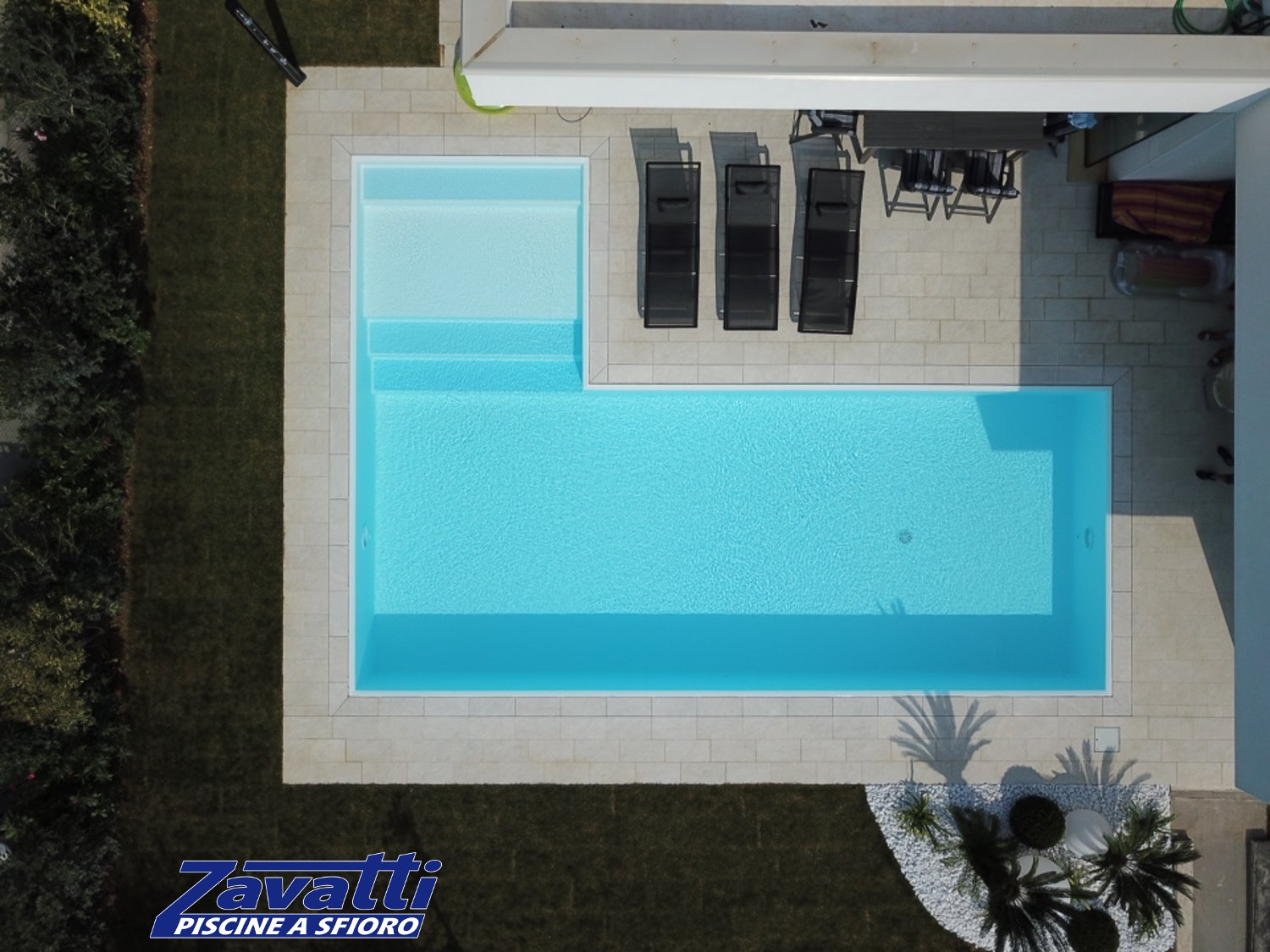 Foto aerea piscina a sfioro senza vasca di compenso con bordo sfioratore a scomparsa e rivestimento bianco