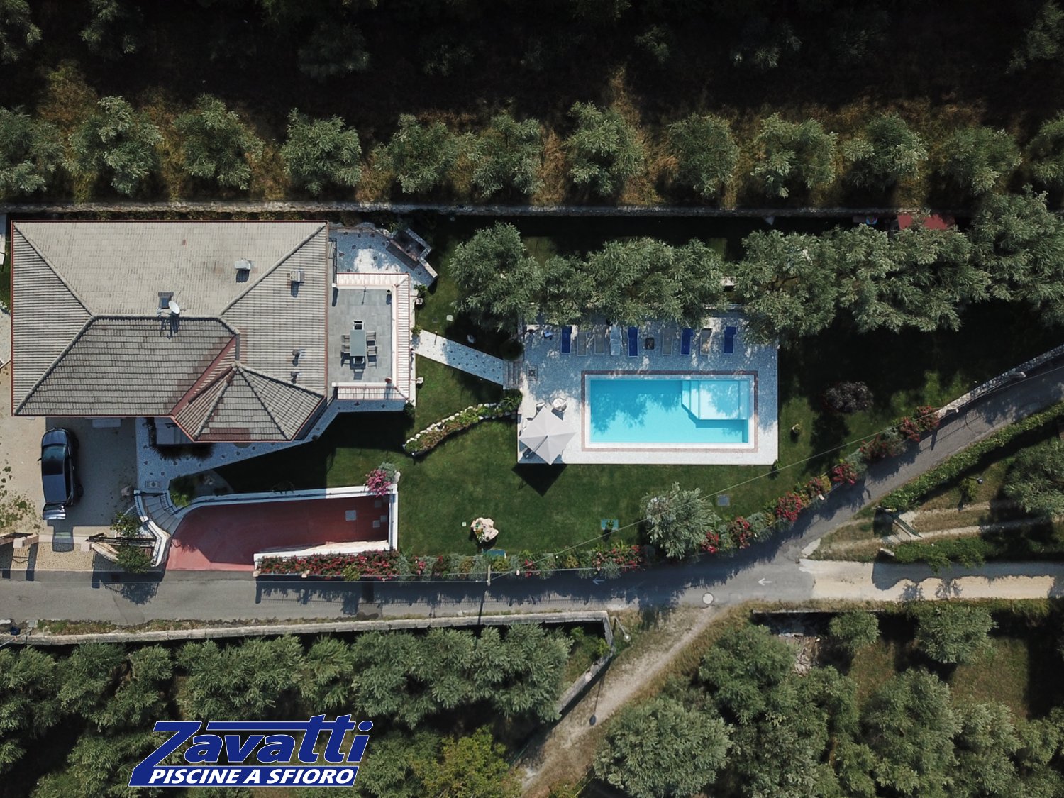 Ripresa aerea da drone di una piscina a sfioro Zavatti immersa nel verde