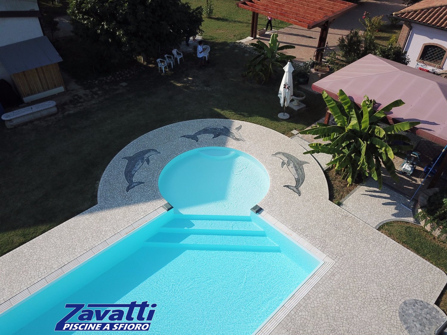 Vista aerea piscina a sfioro con bagnasciuga circolare angolare
