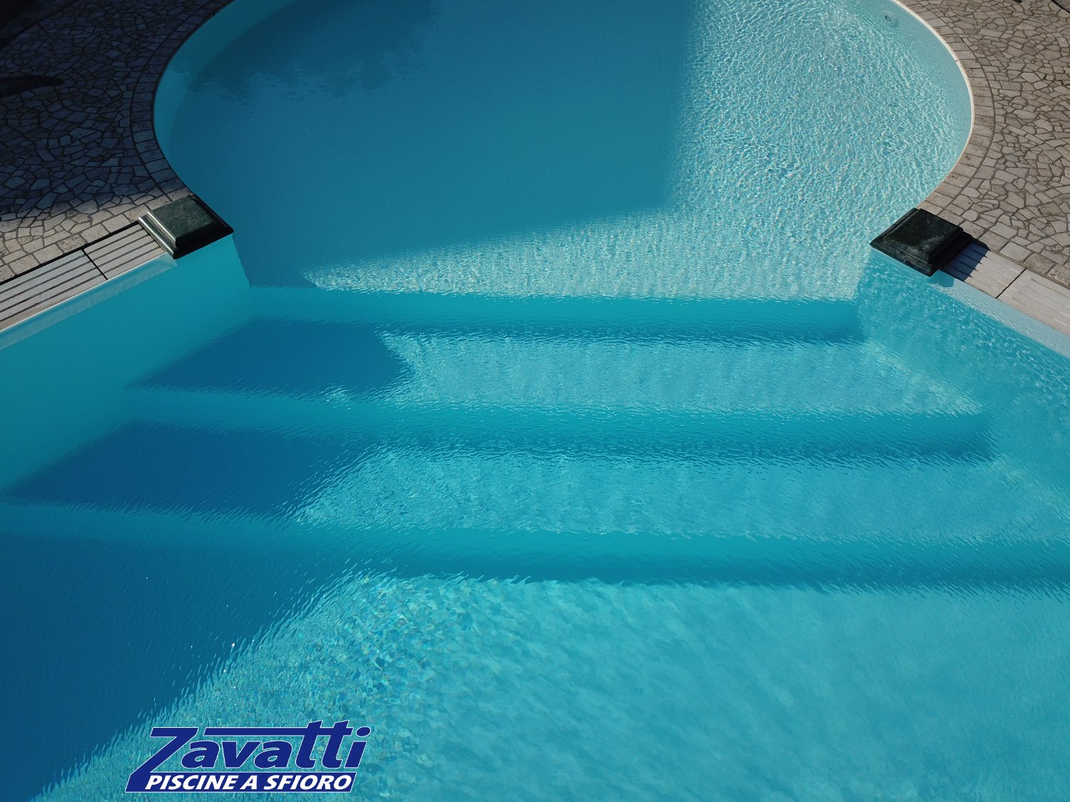 Dettaglio scalini piscina a sfioro con zona relax circolare