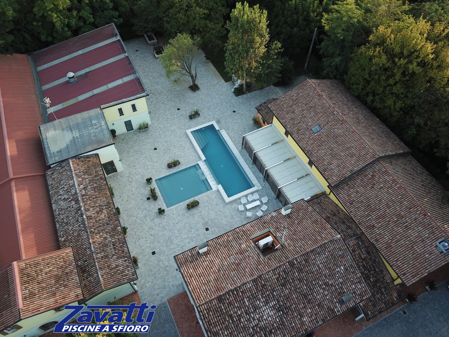 Vista da drone di una piscina a sfioro Zavatti con liner ad alta pigmentazione grigio scuro